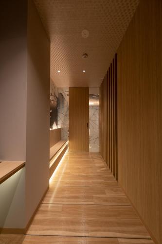 a long hallway with wood paneling and a wooden floor at HOTELみなと-MINATO- in Tokyo