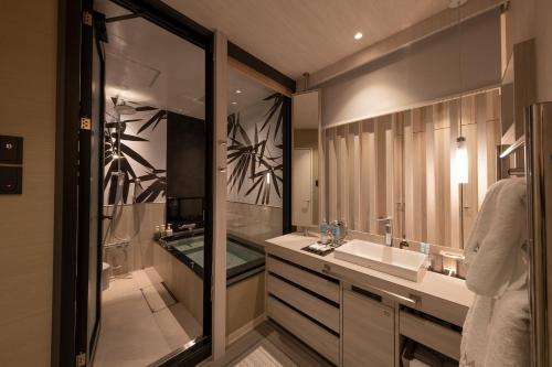 a bathroom with a sink and a shower and a mirror at HOTELみなと-MINATO- in Tokyo