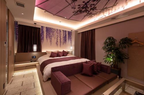 a bedroom with a large bed and a couch at HOTELみなと-MINATO- in Tokyo