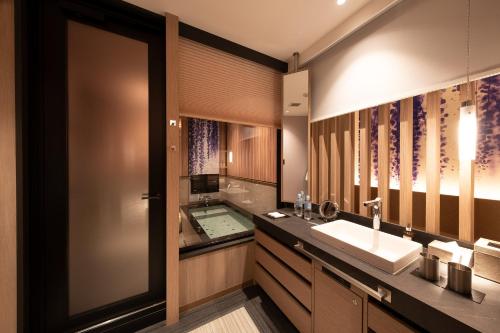 a bathroom with a tub and a sink and a mirror at HOTELみなと-MINATO- in Tokyo