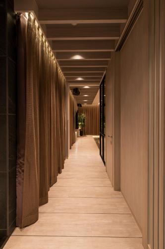 a corridor of a building with brown walls at HOTELみなと-MINATO- in Tokyo