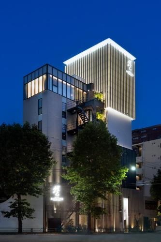 a tall building with trees in front of it at HOTELみなと-MINATO- in Tokyo