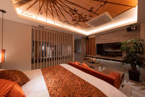 a bedroom with a large bed and a tv at HOTELみなと-MINATO- in Tokyo
