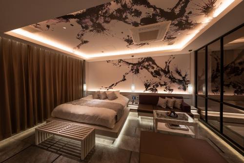 a bedroom with a large bed and a couch at HOTELみなと-MINATO- in Tokyo