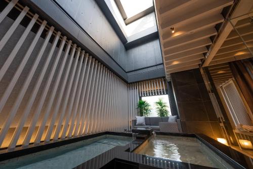 a swimming pool in a building with a skylight at HOTELみなと-MINATO- in Tokyo