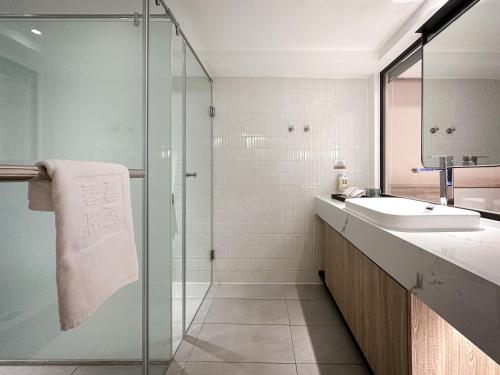 a bathroom with a sink and a glass shower at Spring Rhapsody Hotel in Taichung