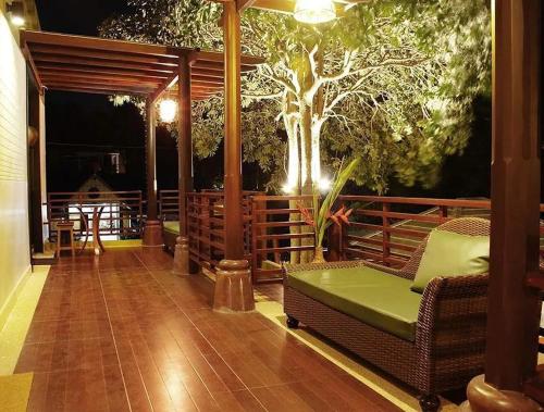 a porch with a couch and a tree at night at Suanmali Samui in Lamai