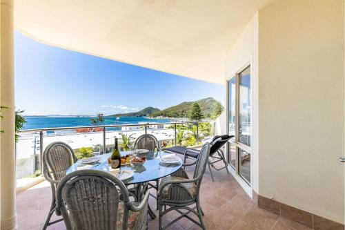 a table and chairs on a balcony with a view of the ocean at 203 The Breakwater 2 Messines St magical unit with lift pool views and aircon in Shoal Bay