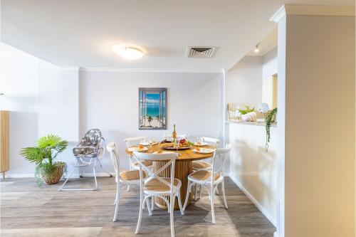 a dining room with a table and chairs at 203 The Breakwater 2 Messines St magical unit with lift pool views and aircon in Shoal Bay