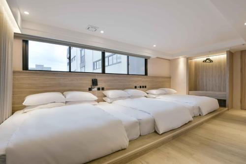 a large bedroom with four beds with white pillows at Spring Rhapsody Hotel in Taichung