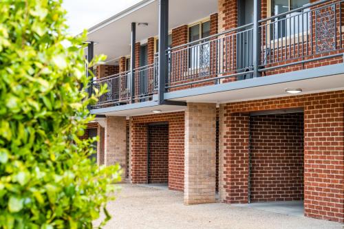 a red brick building with a balcony on it at River Motel in Queanbeyan