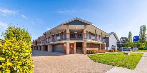 a large house with a balcony on a street at River Motel in Queanbeyan