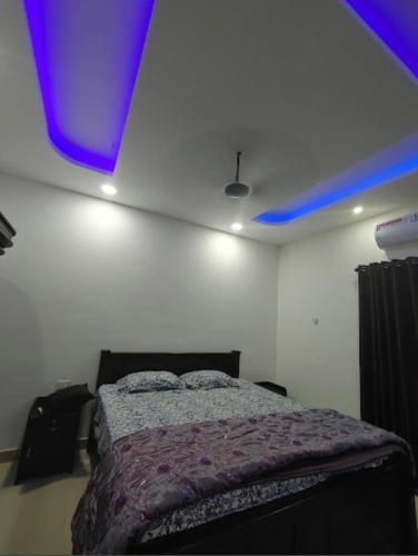 a bedroom with a bed and a purple ceiling at Rain Homestay in Alleppey