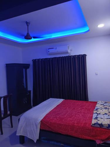 a bedroom with a bed and a blue light at Rain Homestay in Alleppey