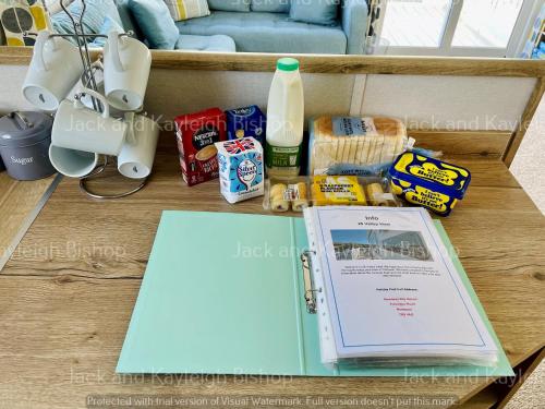 a table with a book and some food and milk at 3-Bedroom Holiday Home with Valley Views in Newquay