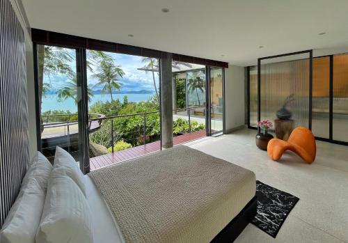 a bedroom with a bed and a view of the ocean at L2 Residence in Laem Set Beach