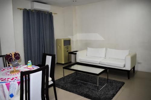 a living room with a white couch and a table at Happy Homes Manila in Manila