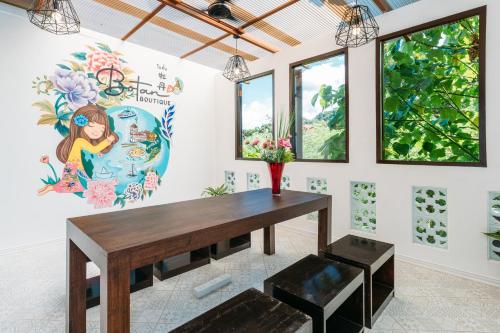 une salle à manger avec une table et un tableau mural dans l'établissement Botan Boutique Hotel, à Patong Beach