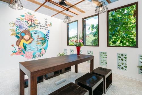 a dining room with a table and a painting on the wall at Botan Boutique Hotel in Patong Beach