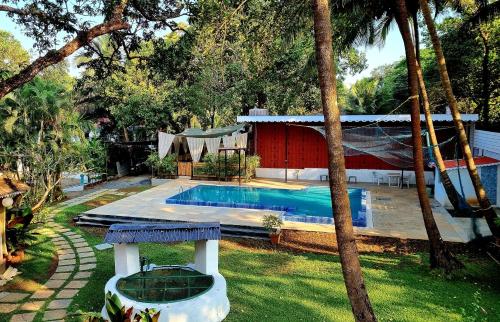 a backyard with a swimming pool and a house at Garden Villa in Vagator
