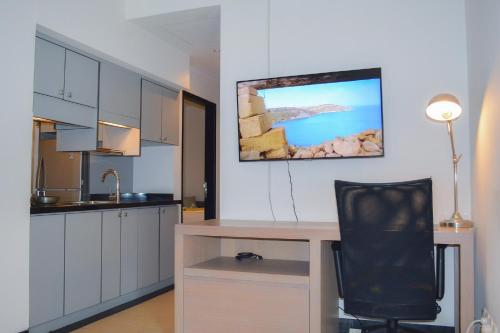 a kitchen with a desk and a black chair at Lemansion Senopati in Jakarta