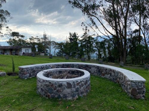 a stone fire pit in the middle of a field at Quinta San Felipe in Atuntaqui