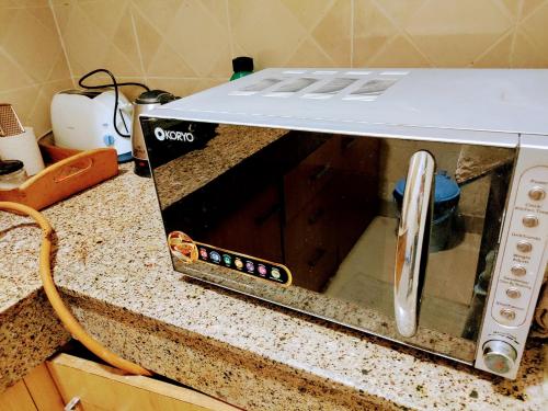 a toaster oven sitting on a kitchen counter at Entire Studio Apt/Suite near Mall/Metro/ExpoMart in Noida