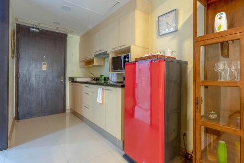 a kitchen with a red refrigerator in a room at Citismart Luxury Apartments in Pattaya Central