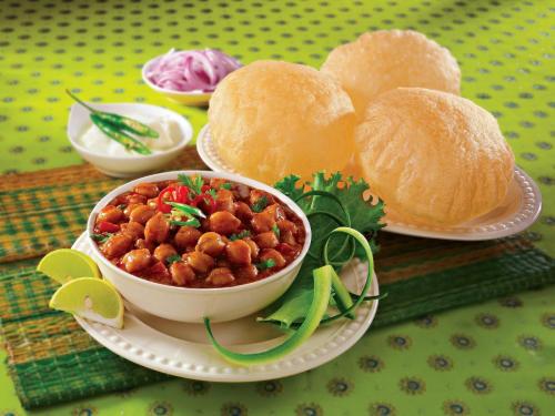 a plate of food with a bowl of beans and bread at Hotel Sterling Inn in Bangalore