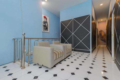 a room with a white couch and a blue wall at RedDoorz near Mayapada Hospital Surabaya in Surabaya