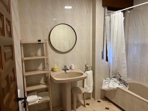 un bagno con un lavandino, uno specchio e una vasca di EL RECREO a Mojados