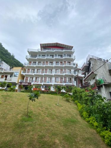 Un gran edificio blanco con un patio delante. en Hotel Shiva Yog Sthal, en Rishīkesh