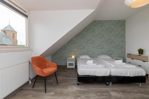 1 dormitorio con 1 cama y 1 silla naranja en Willibrordusplein 28e, en Zoutelande