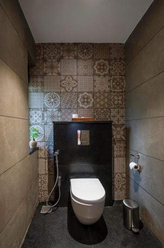 a bathroom with a white toilet in a room at Klov Resort & Spa in Wayanad
