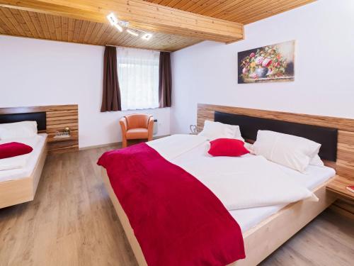a bedroom with a large bed with a red blanket on it at Apartment in St Kanzian am Klopeinersee with garden in Wasserhofen