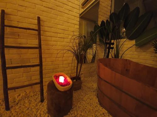 a candle in a pot in a room with a brick wall at Language Exchange Hotel 3 in Ho Chi Minh City