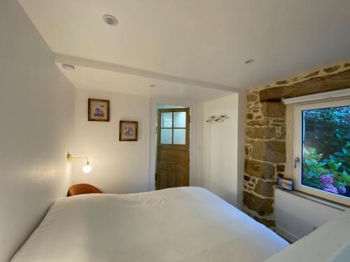 a bedroom with a white bed and a window at Studio cosy tout équipé en cœur de ville au calme in Guingamp