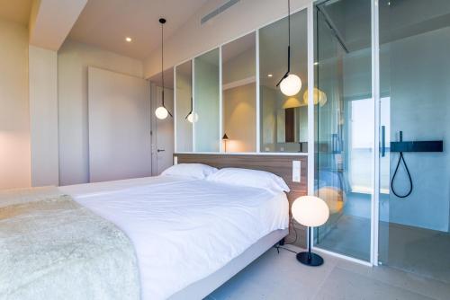 ein Schlafzimmer mit großem Bett und Glaswand in der Unterkunft BEACH NEST VILLA in Son Serra de Marina