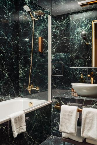 a bathroom with a tub and a sink at St Palace Hotel in Vilnius