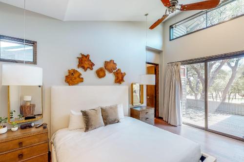 een slaapkamer met een wit bed en een groot raam bij Riverbend Cabin #015 in Spicewood