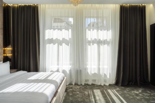 a bedroom with a bed and a large window at St Palace Hotel in Vilnius