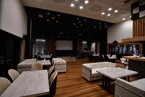 a restaurant with white tables and white chairs at Villa 33 Kashikojima in Ugata