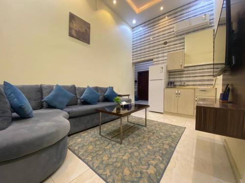 sala de estar con sofá, mesa y cocina en القصر المطار en Abha