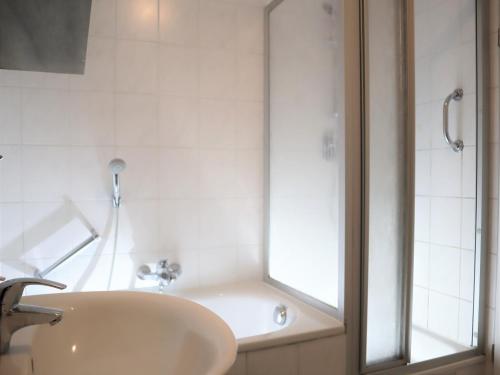 a white bathroom with a sink and a shower at Ferienwohnung am Clara Park in Leipzig