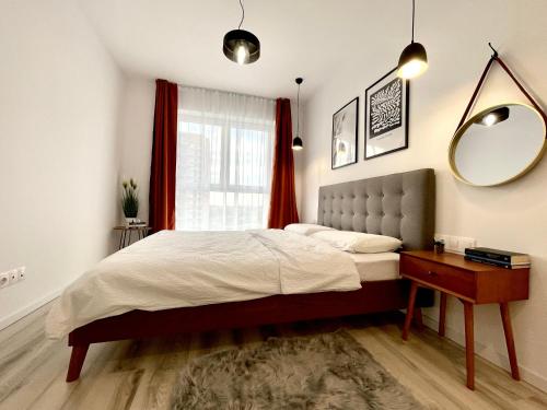 a bedroom with a bed and a mirror and a table at Sunset View Apartment in Timişoara