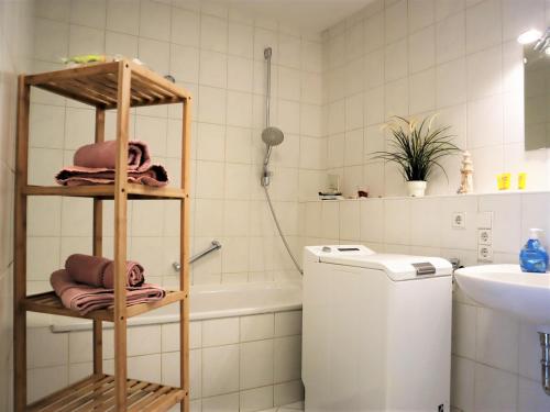 a bathroom with a tub and a sink and a towel rack at Exklusive Wohnung mit Dachterrasse in Schleußig in Leipzig