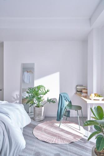 a bedroom with a chair and a desk and plants at M Village Living Lê Văn Sỹ in Ho Chi Minh City