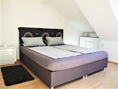 1 dormitorio con 1 cama con cabecero negro en Kuschelige Dachgeschosswohnung am Clarapark, en Leipzig