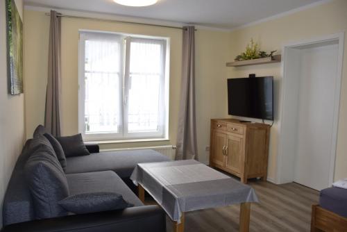 a living room with a couch and a tv at Hotel Garni Am Klostermarkt in Plauen