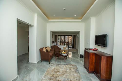 a living room with a couch and a tv at AIFU Hotel El Montazah Alexandria in Alexandria